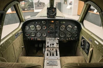 Vue intérieure du cockpit du Bf 109 G montrant le tableau de bord avec ses cadrans analogiques, le viseur Revi et les commandes d'époque en bakélite usée