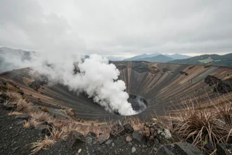 Volcan japonais Mont Aso au Japon avec vapeurs sulfureuses s'échappant du cratère dans un paysage volcanique dramatique